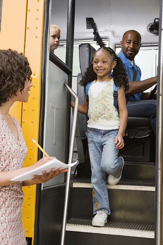 Group organizer making notes of students on bus