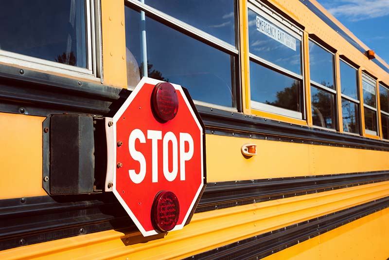 Stop sign on the side of a school bus