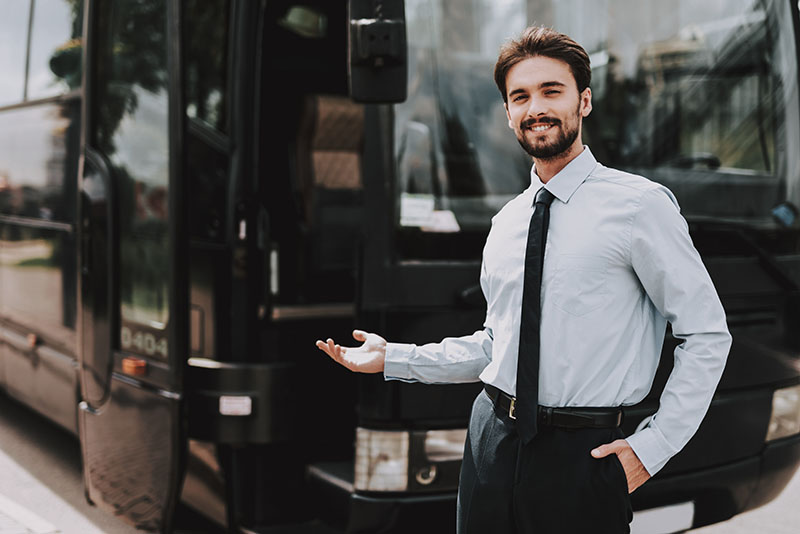 Businessman standing in front of a corporate motorcoach bus
