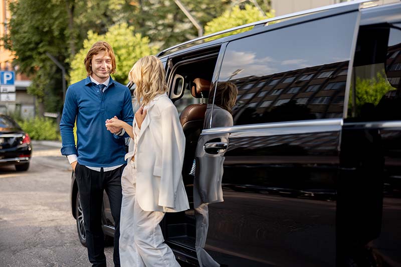 Two businesspeople getting out of a corporate shuttle